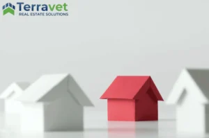 House made of red paper, next to white paper houses to represent Real Estate Investment Trusts