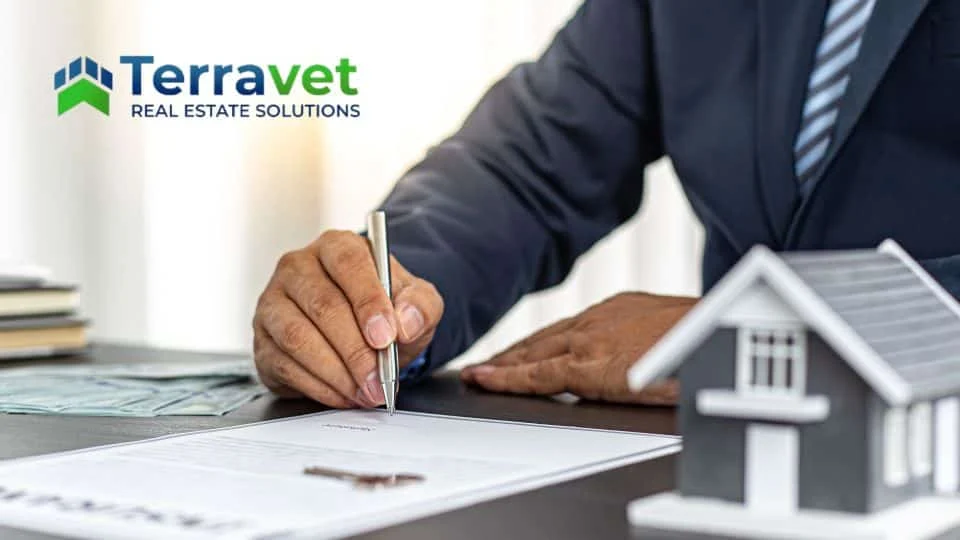 Terravet Real Estate Solutions business man signing document next to model house representing insurance considerations