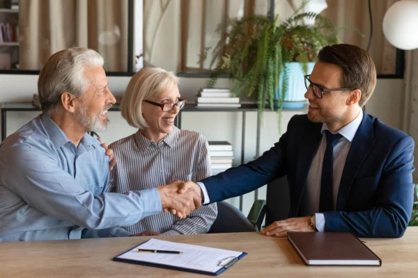 Investor shaking hands with older couple